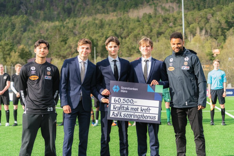 Bjørn Martin Kristensen, Sten Grytebust og resten av spillergruppa i AaFK har bestemt hvem som skal motta scoringsbonusen for 2022. Her under overrekkelsen på Blindheim stadion 8. mai. Foto: aafk.no